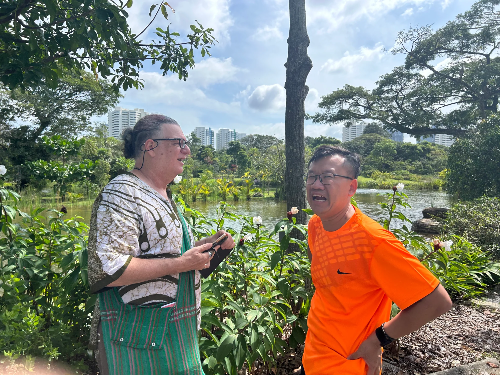 Tour guide chatting with a guest beside the lake at Jurong Lake Gardens