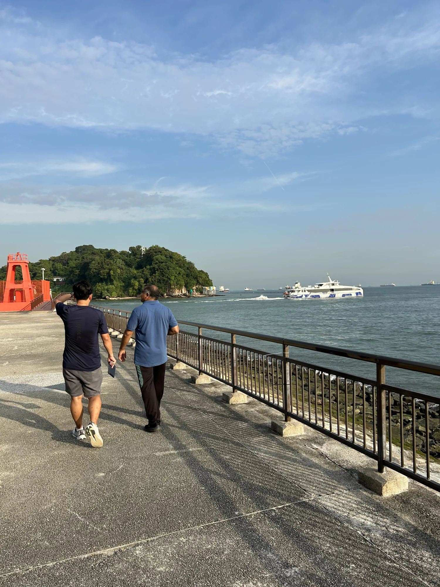 Tour guide and guest walking the Labrador Park waterfront towards the Red Beacon