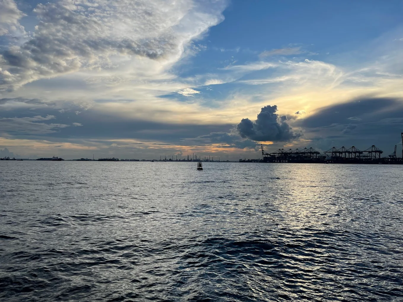 Sunset over the sea at Labrador Nature Reserve, with the port cranes on the horizon