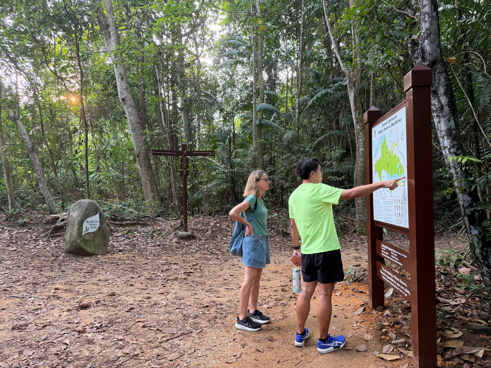 Tour guide pointing out the route on a MacRitchie Nature Reserve trail map