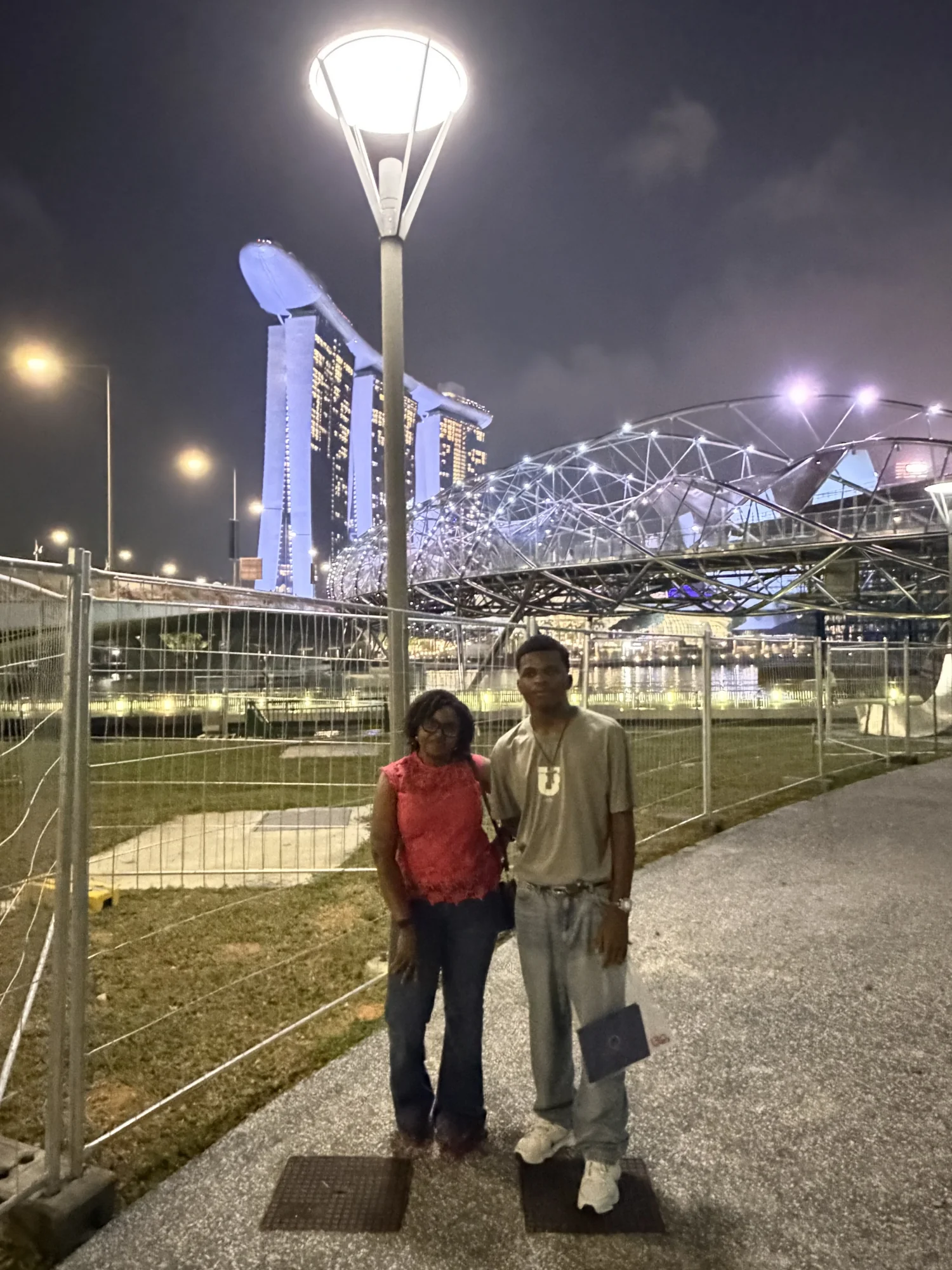 Walking tour guests in front of Marina Bay Sands and the Helix Bridge at night