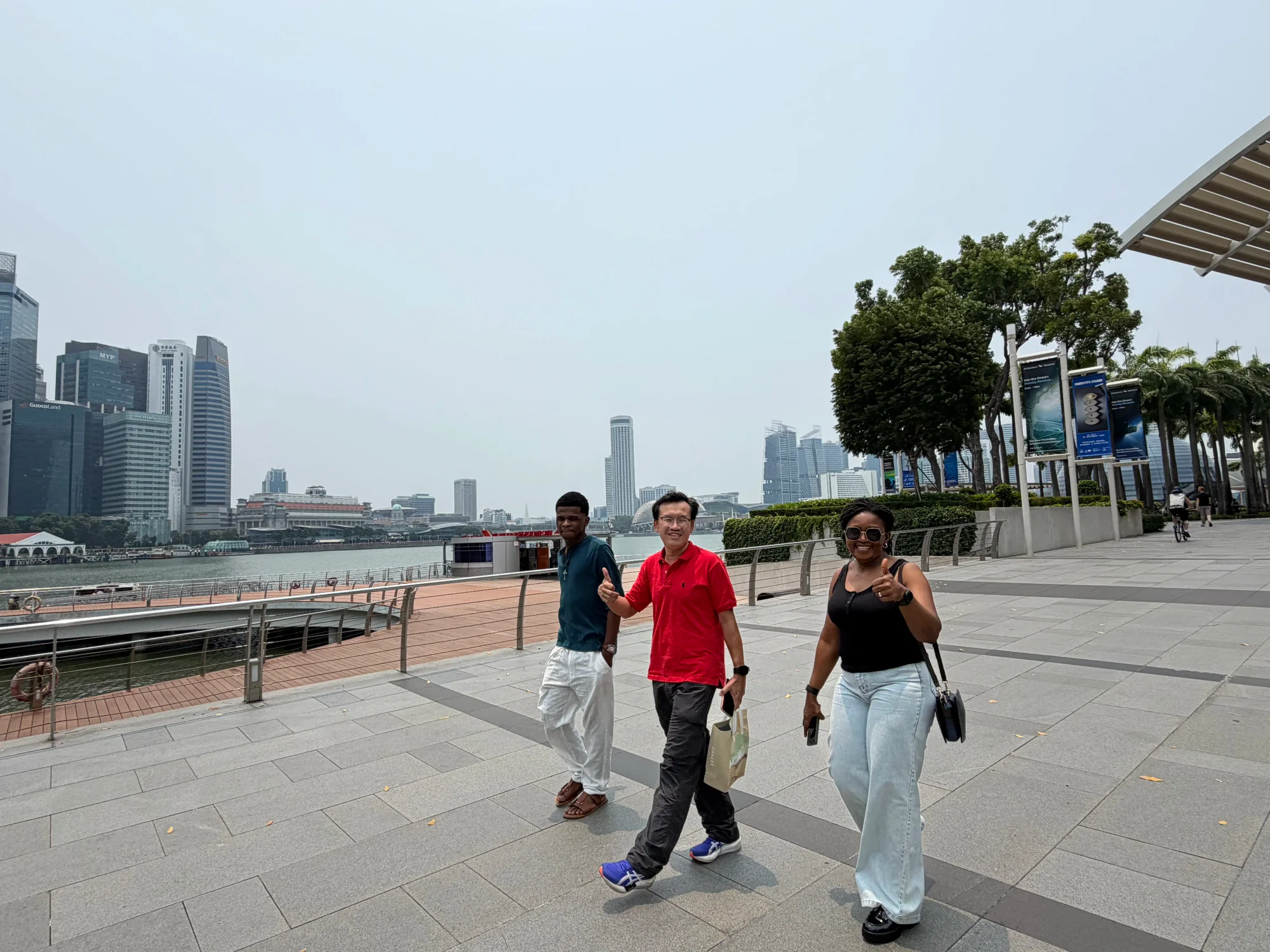Tour guide walking guests along the Marina Bay waterfront with the city skyline behind