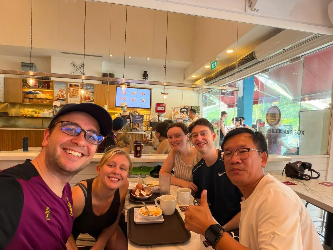 Tour guide and guests taking a group selfie over breakfast after the walk